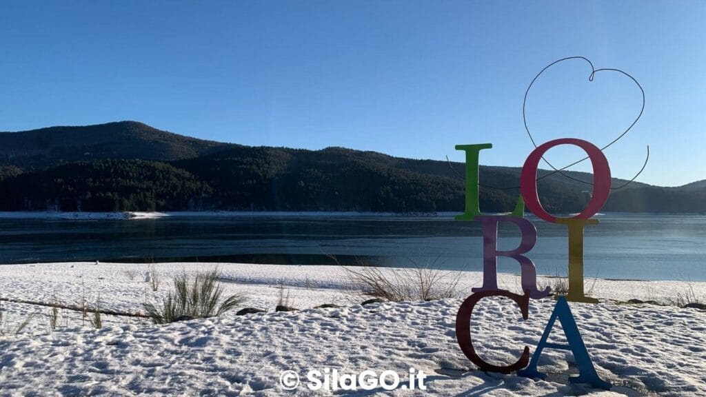 Lago Arvo innevato a Lorica, con le montagne della Sila sullo sfondo.