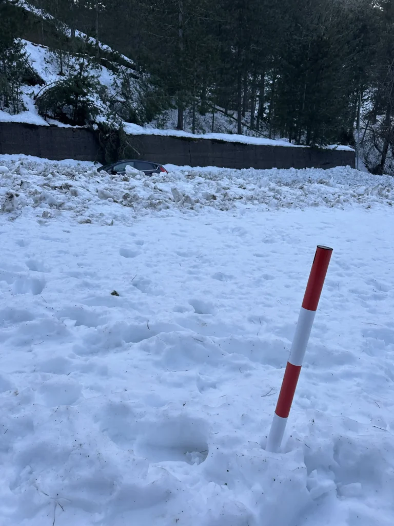 Neve alta con un'auto sullo sfondo